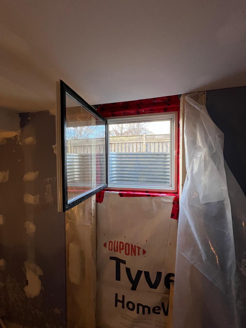 Egress window open from inside upgraded with black color on outside project by sv constructions and services inc.